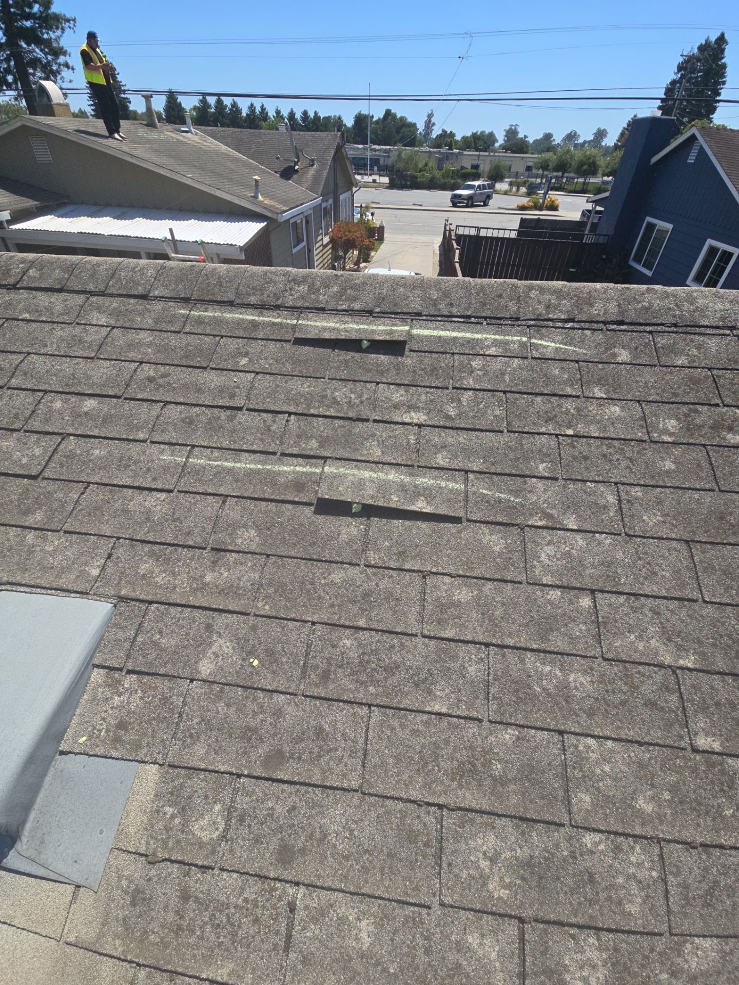 Weathered roof shingles showing repair patches documented during a storm damage inspection